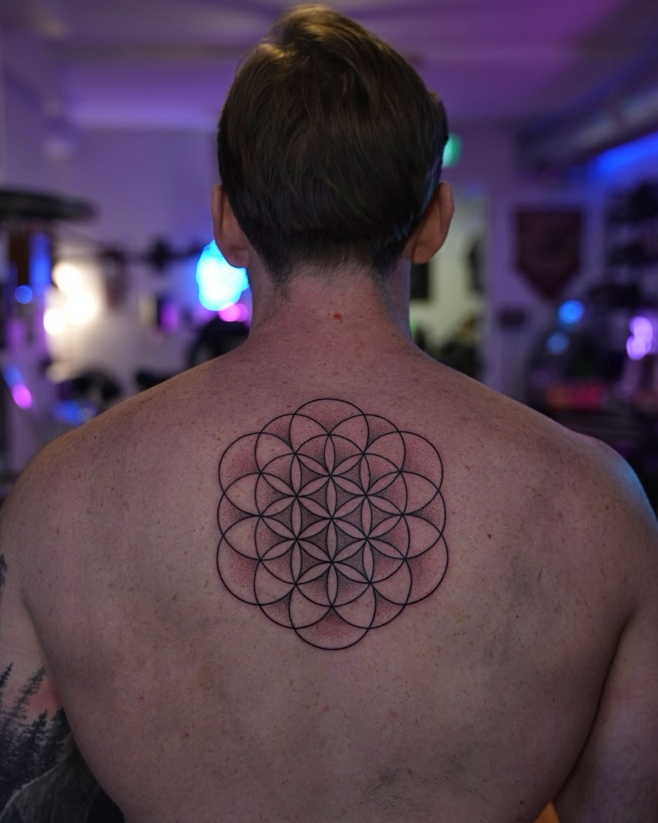 Intricate Flower of Life back tattoo with delicate linework