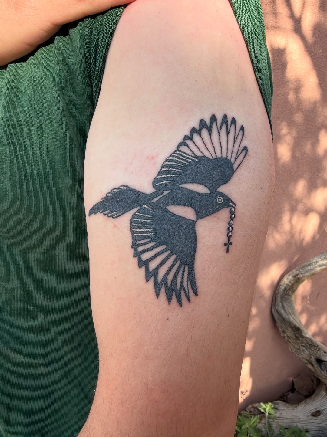 Black bird tattoo on arm