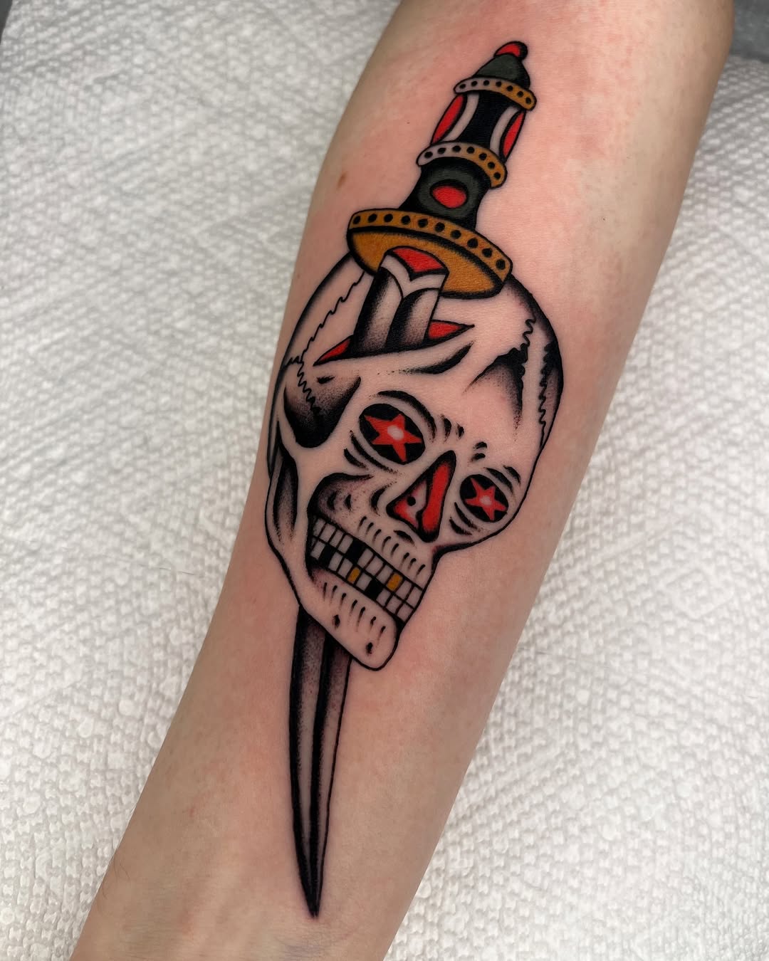 Classic bold skull with dagger, red star eyes, strong blackwork