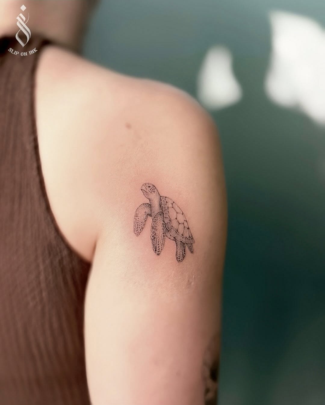 Delicate fineline turtle with stippled shading on upper arm