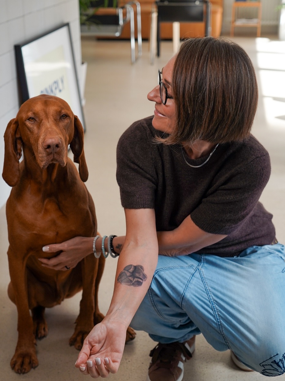 Bold black paw-print tattoo on the inner forearm