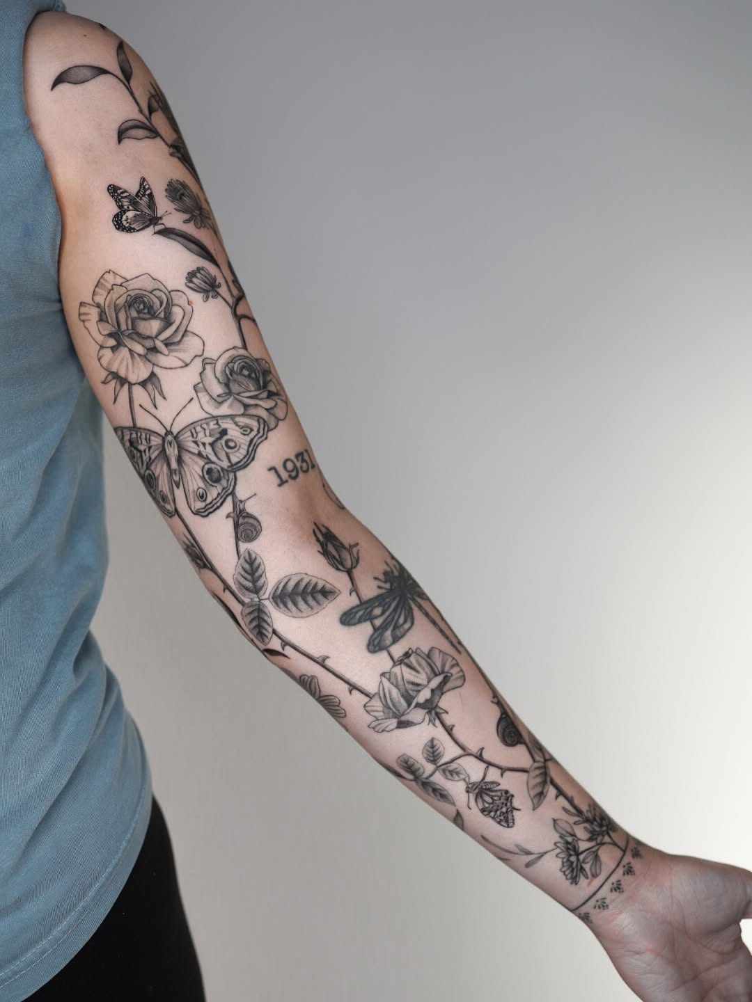 Intricate black-and-gray botanical sleeve with roses and butterfly