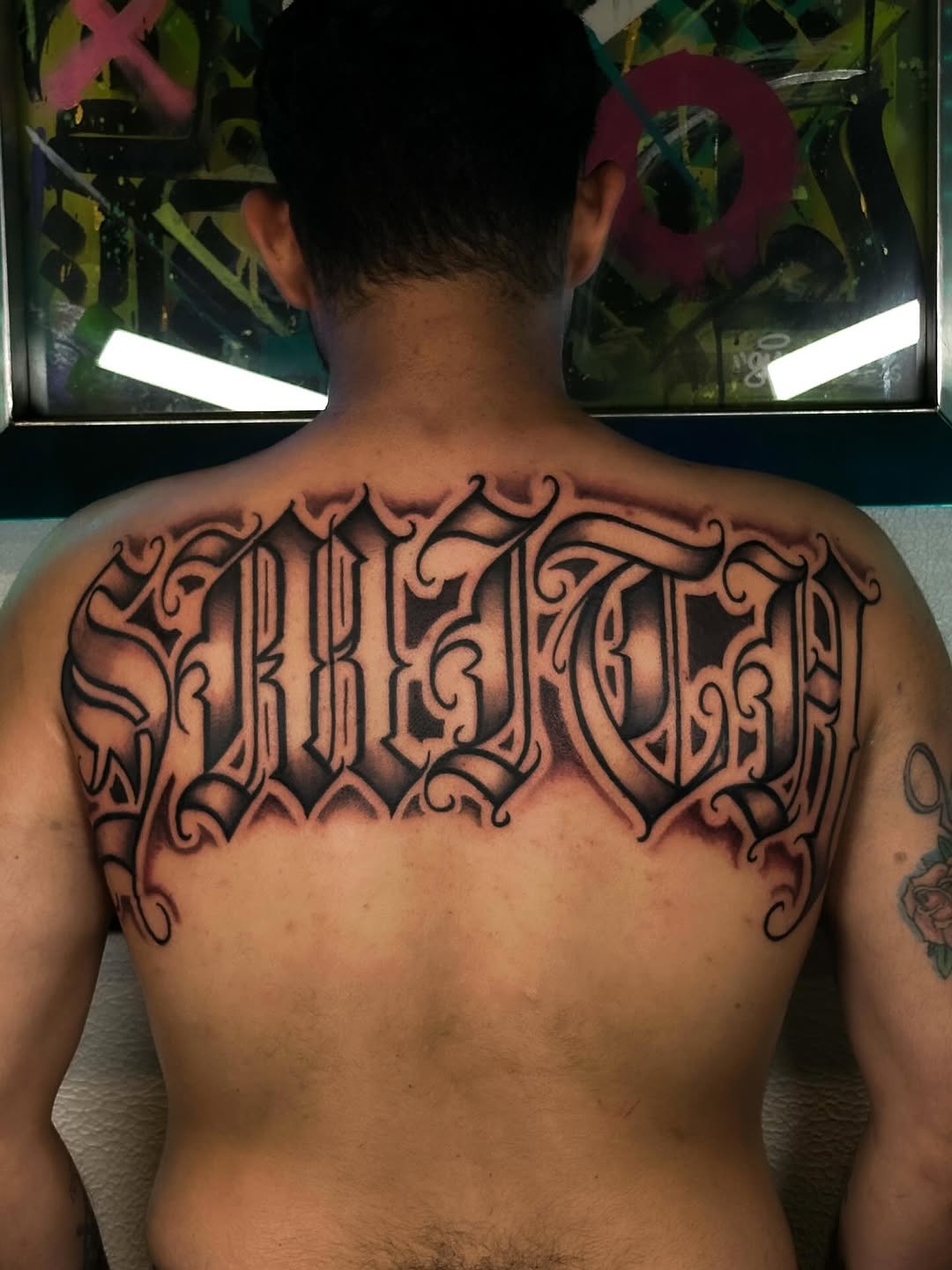 Bold blackletter back piece with ornate flourishes.