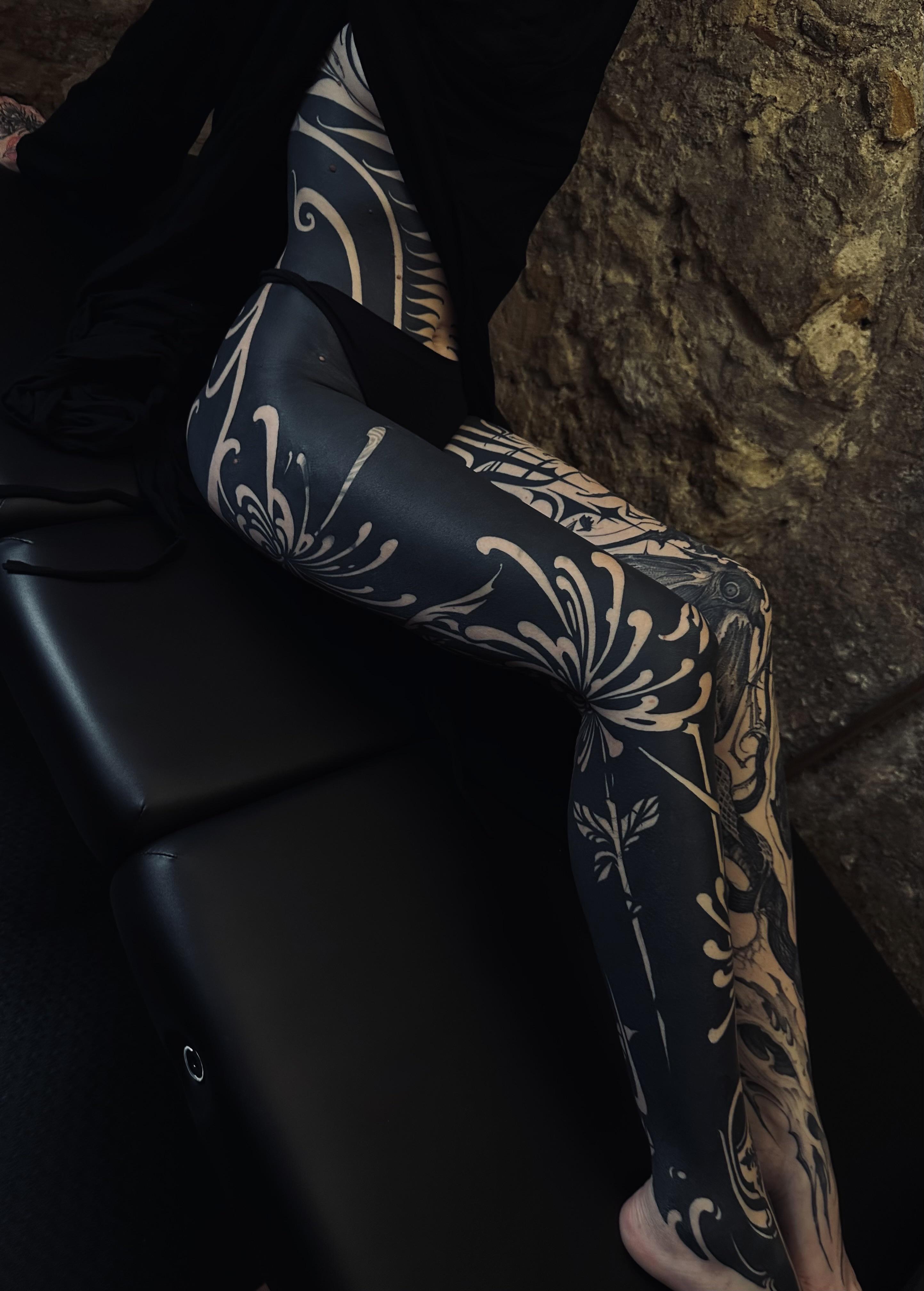 Elaborate blackwork ornamental leg piece with floral motifs.