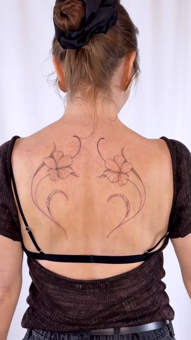 Delicate back-piece with twin hibiscus and curling vines.