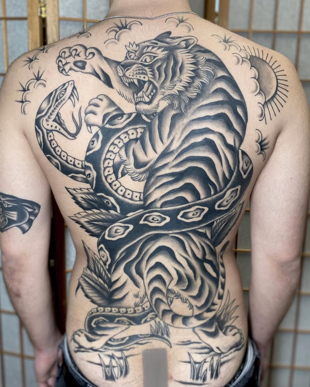 Monumental blackwork back piece featuring tiger and serpent