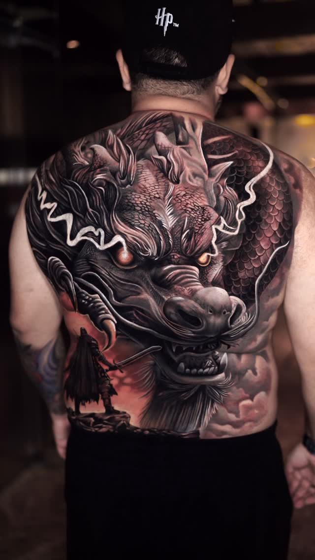 Monumental black-and-gray dragon backpiece with intricate scales