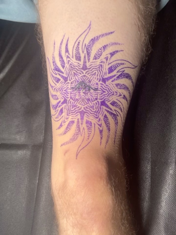 Psychedelic sun mandala with geometric dotwork on forearm