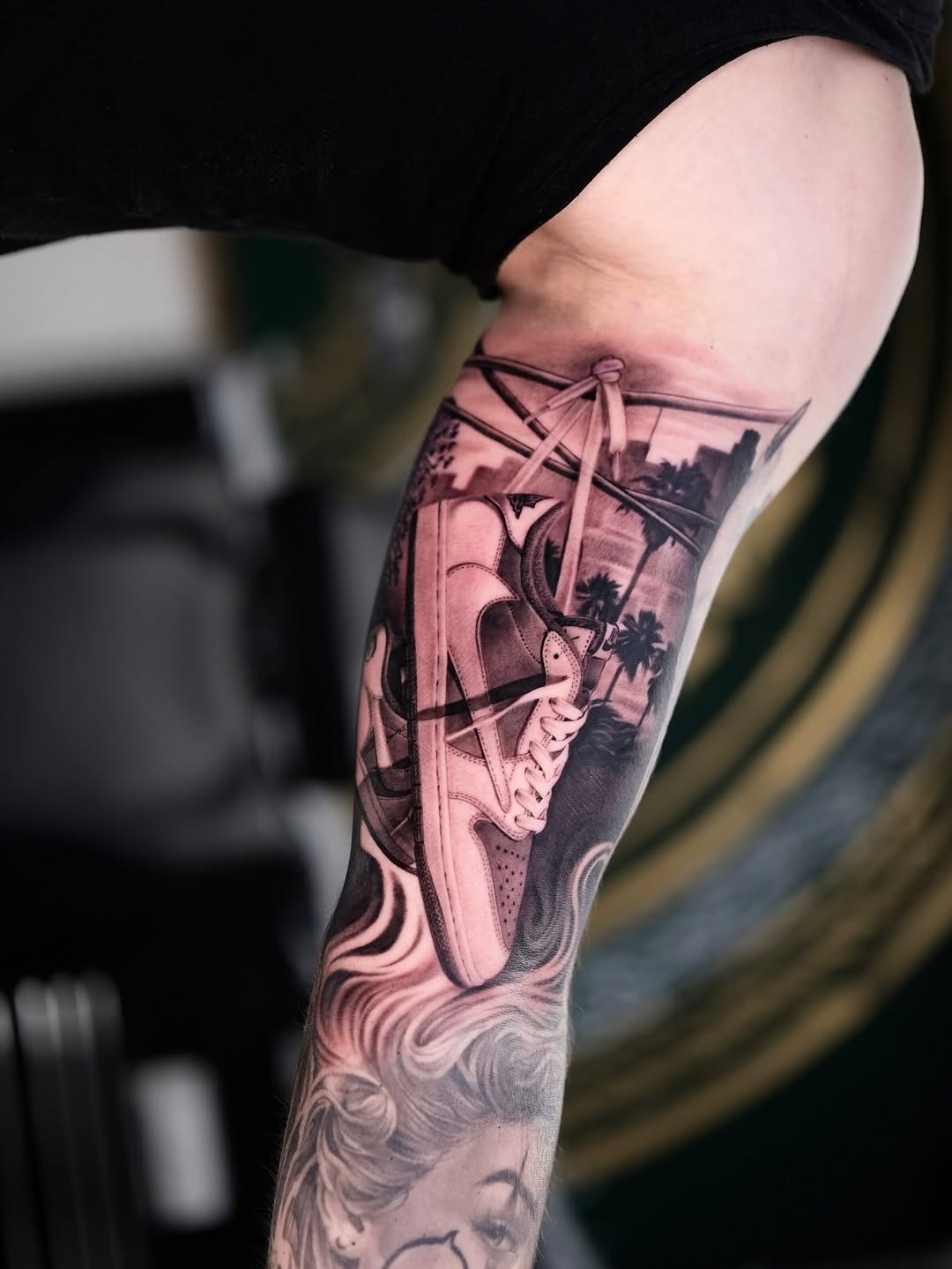 Hyper-detailed monochrome sneaker tattoo with urban skyline