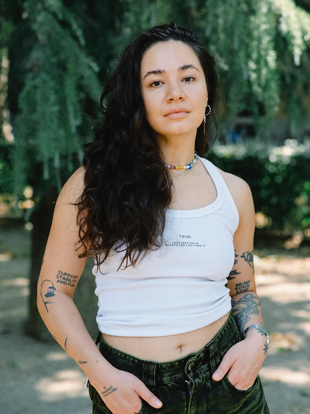 Text-driven blackwork with fine-line arm tattoos and slogans