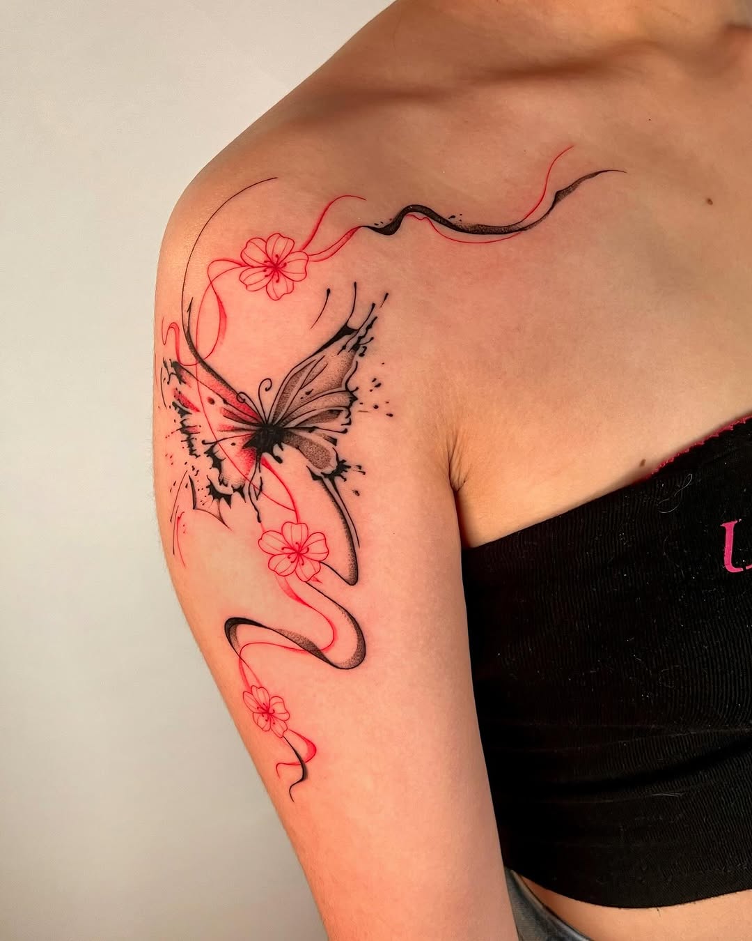 Delicate butterfly with flowing red floral lines.