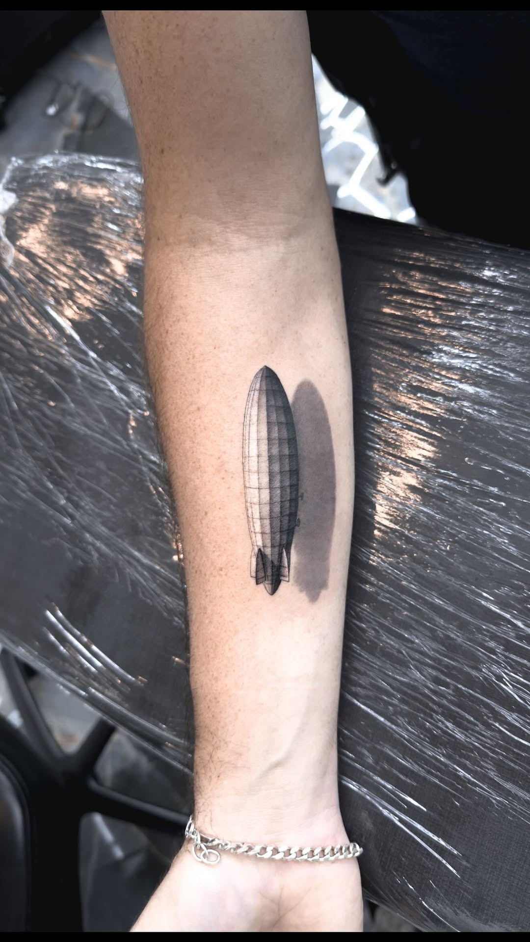 Sleek airship silhouette with segmented panel shading in blackwork