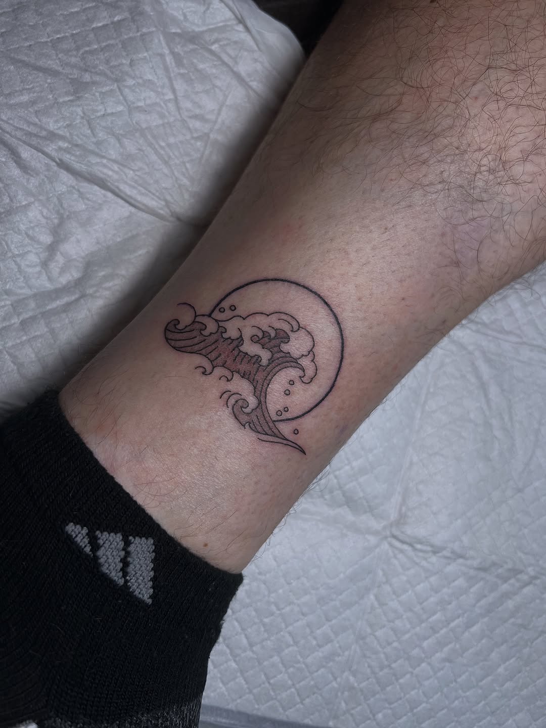 Sleek black-line wave enclosed in a circle, minimalist