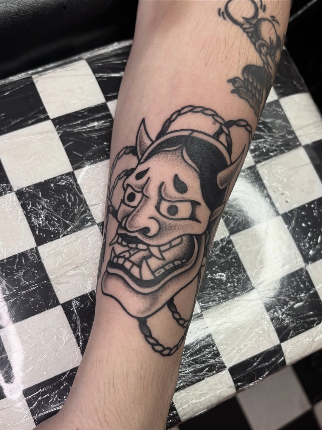 Bold oni mask with horns, snarling, rope accents