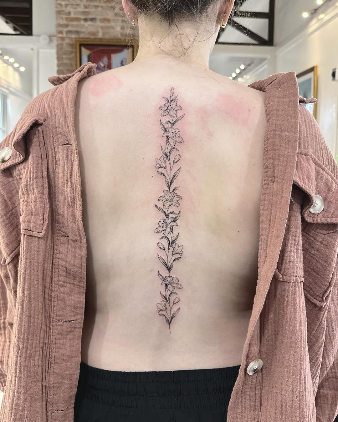 Delicate vertical botanical linework of flowers along spine