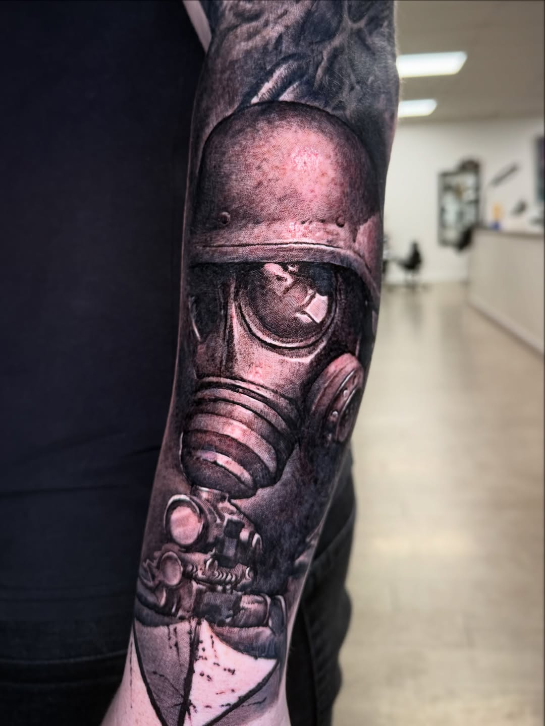 Hyper-detailed grayscale gas-mask realism on forearm