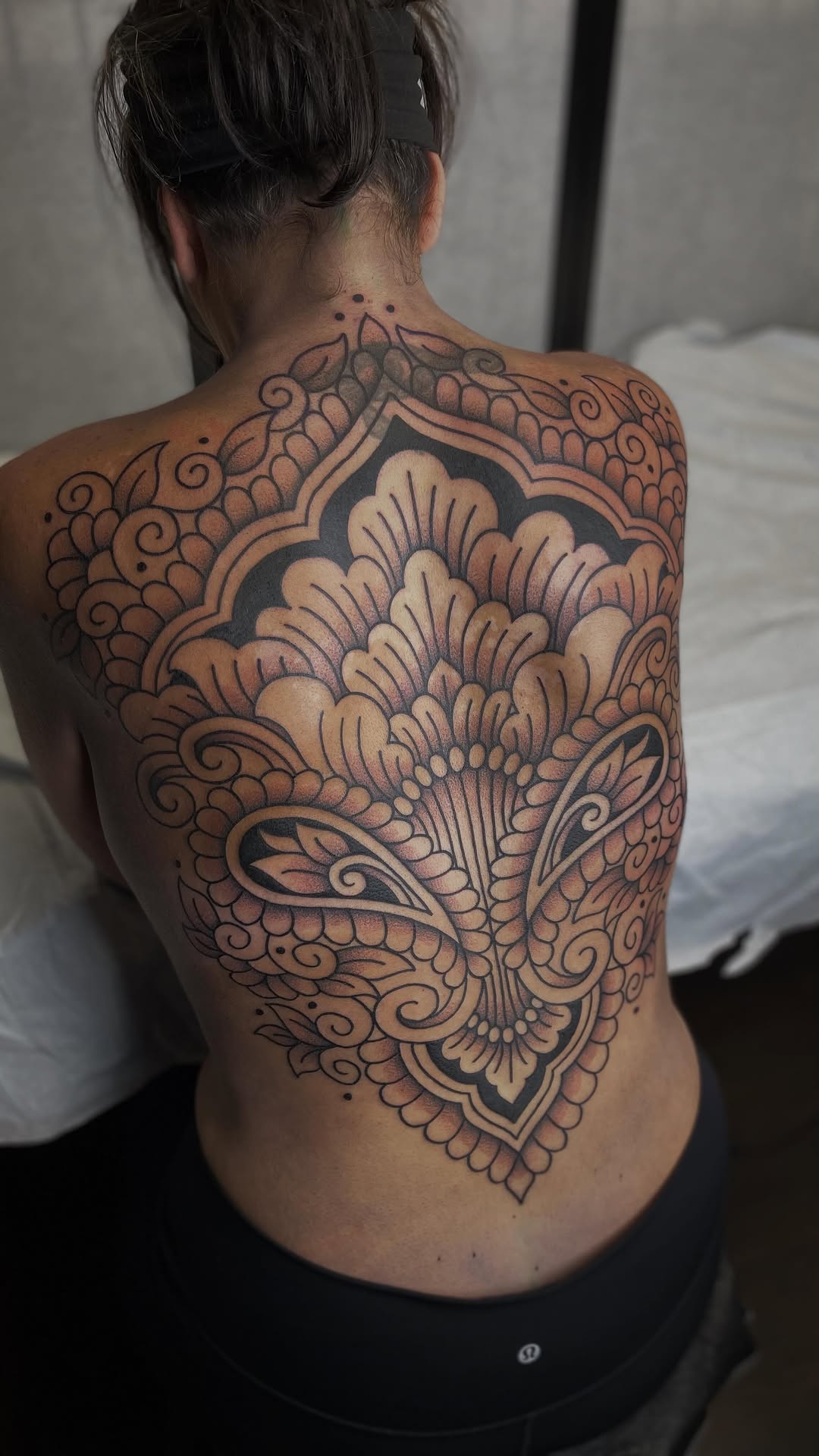 Intricate ornamental backpiece with bold black floral arabesques