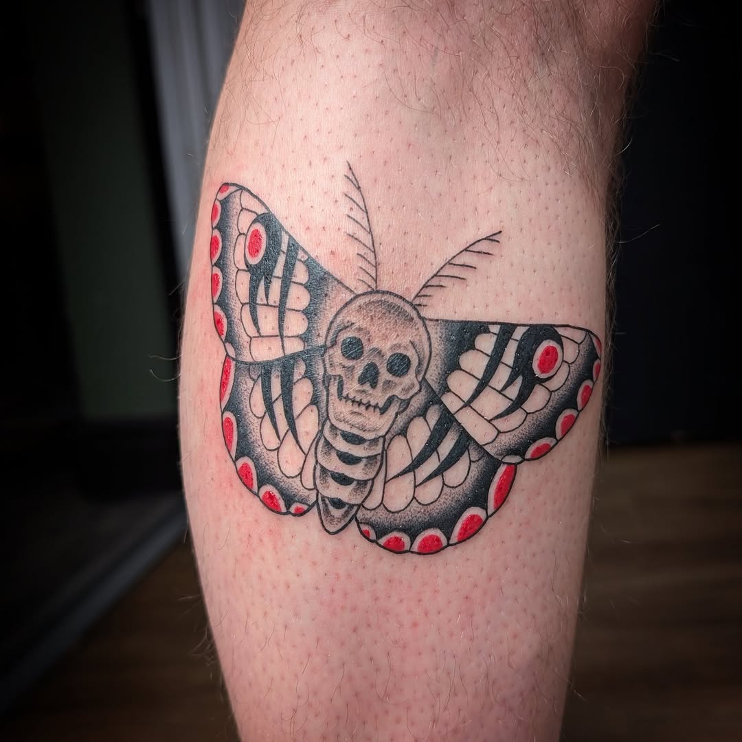 Bold neo-traditional butterfly with skull centerpiece, red accents