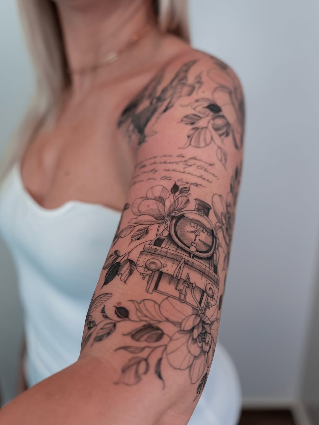 Intricate black-line floral sleeve with steam locomotive