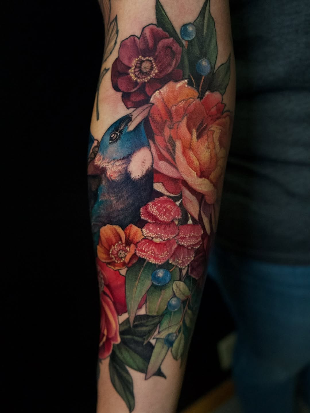 Vibrant floral bouquet surrounding a vivid blue bird.