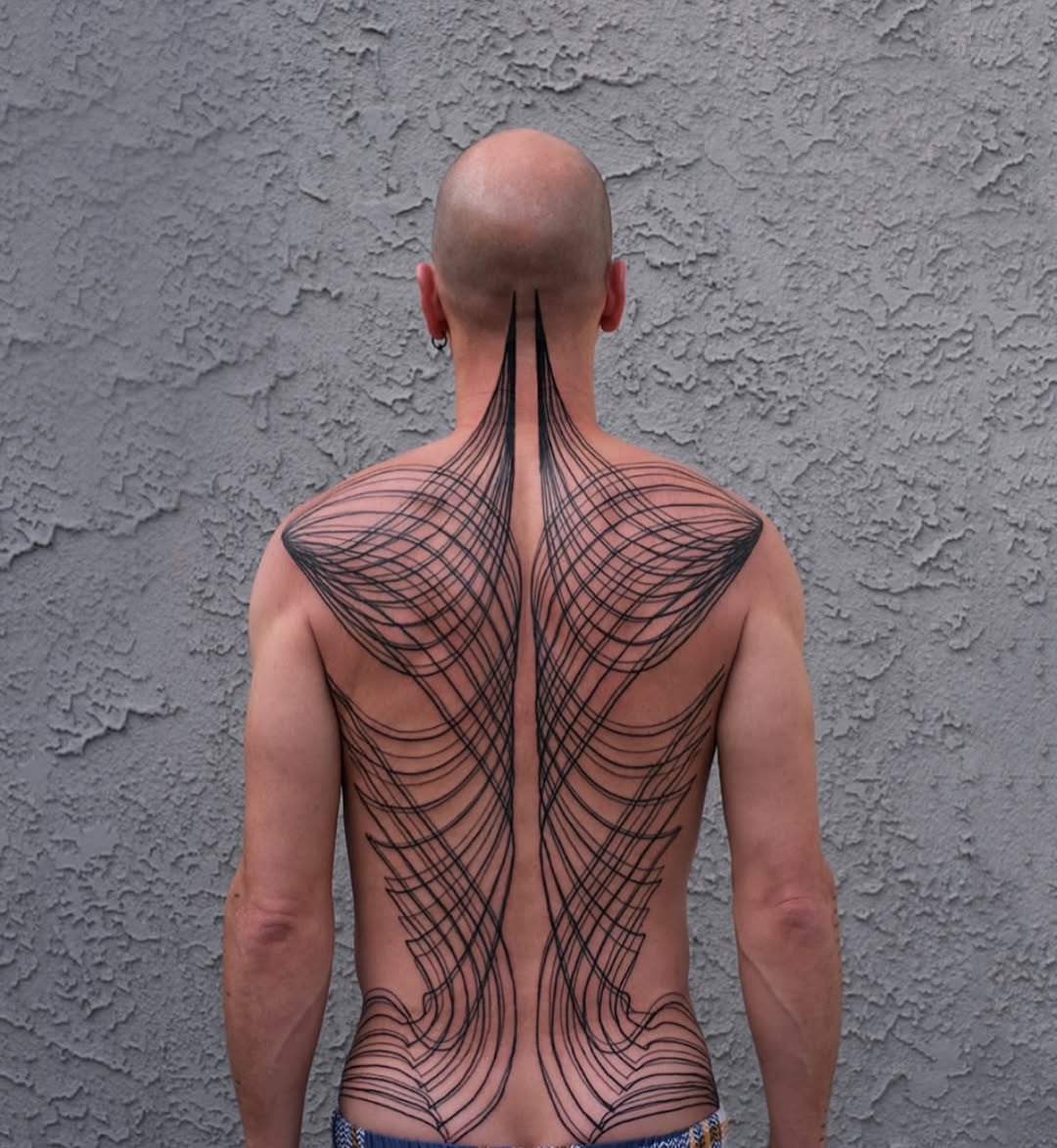 Intricate symmetric linework back piece with radiating arcs.