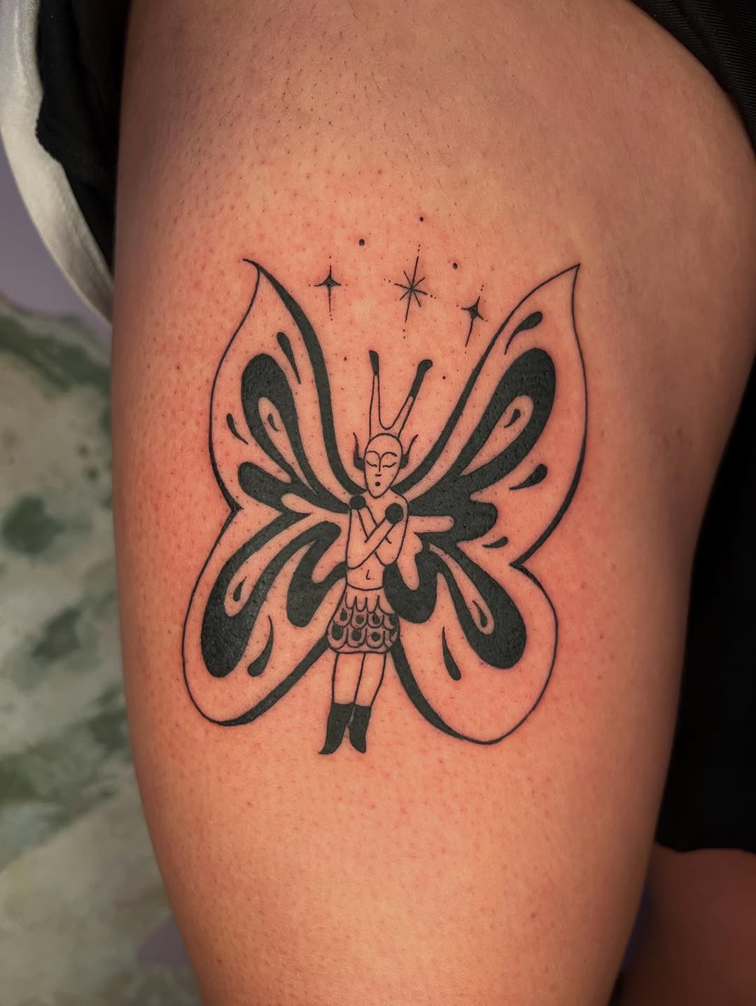 Whimsical butterfly with a tucked fairy figure.