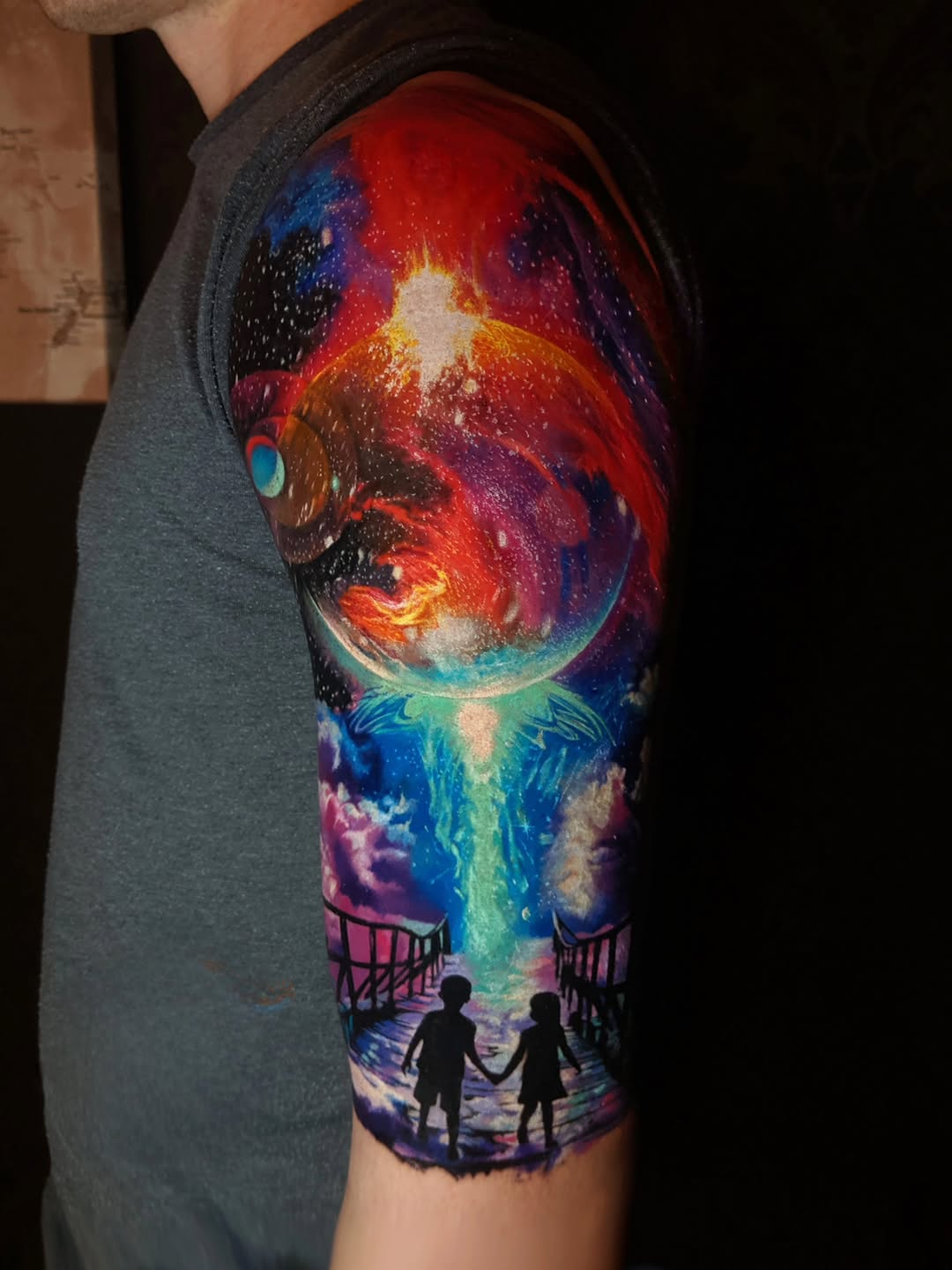 Vibrant galaxy scene with silhouetted children on a bridge