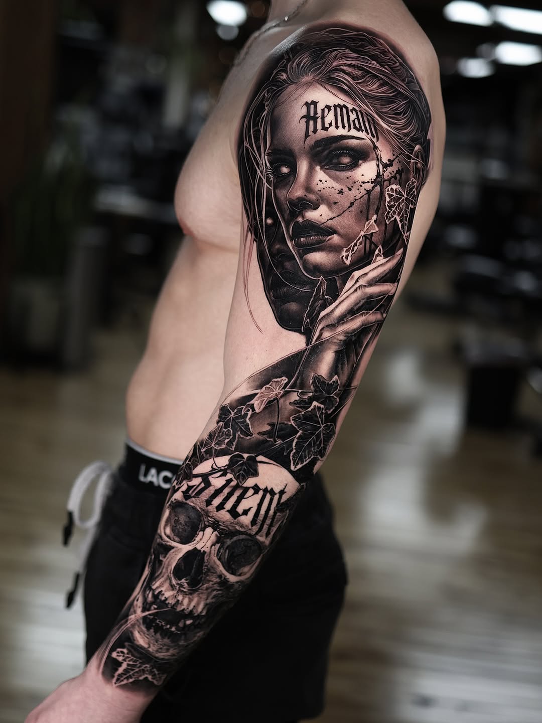 Photorealistic black-and-gray sleeve, female portrait with ivy and skull.