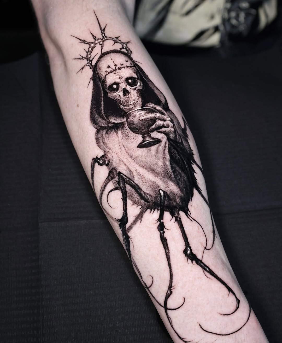 Macabre hooded skeleton sipping goblet, haloed gloom