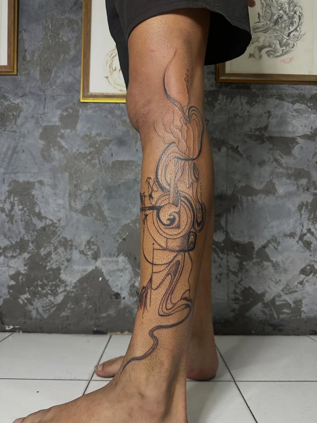 Fluid abstract linework spirals along the shin and ankle.