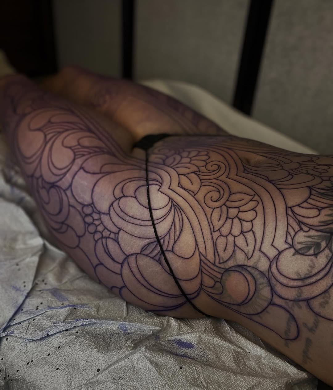Intricate ornamental floral linework across the leg.