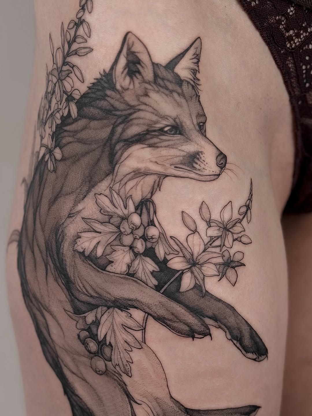 Sleek fox intertwined with delicate botanical blossoms in grayscale.