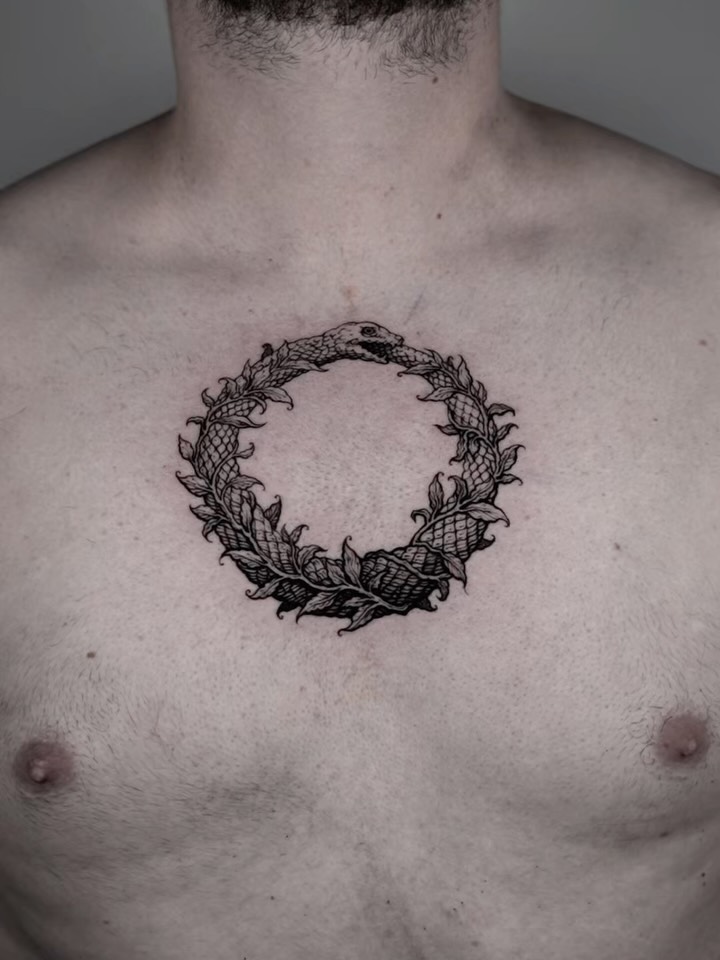 Clean blackwork ouroboros encircled by laurel leaves