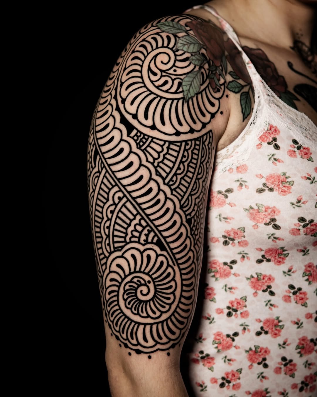 Bold blackwork upper-arm ornamental swirls and spirals