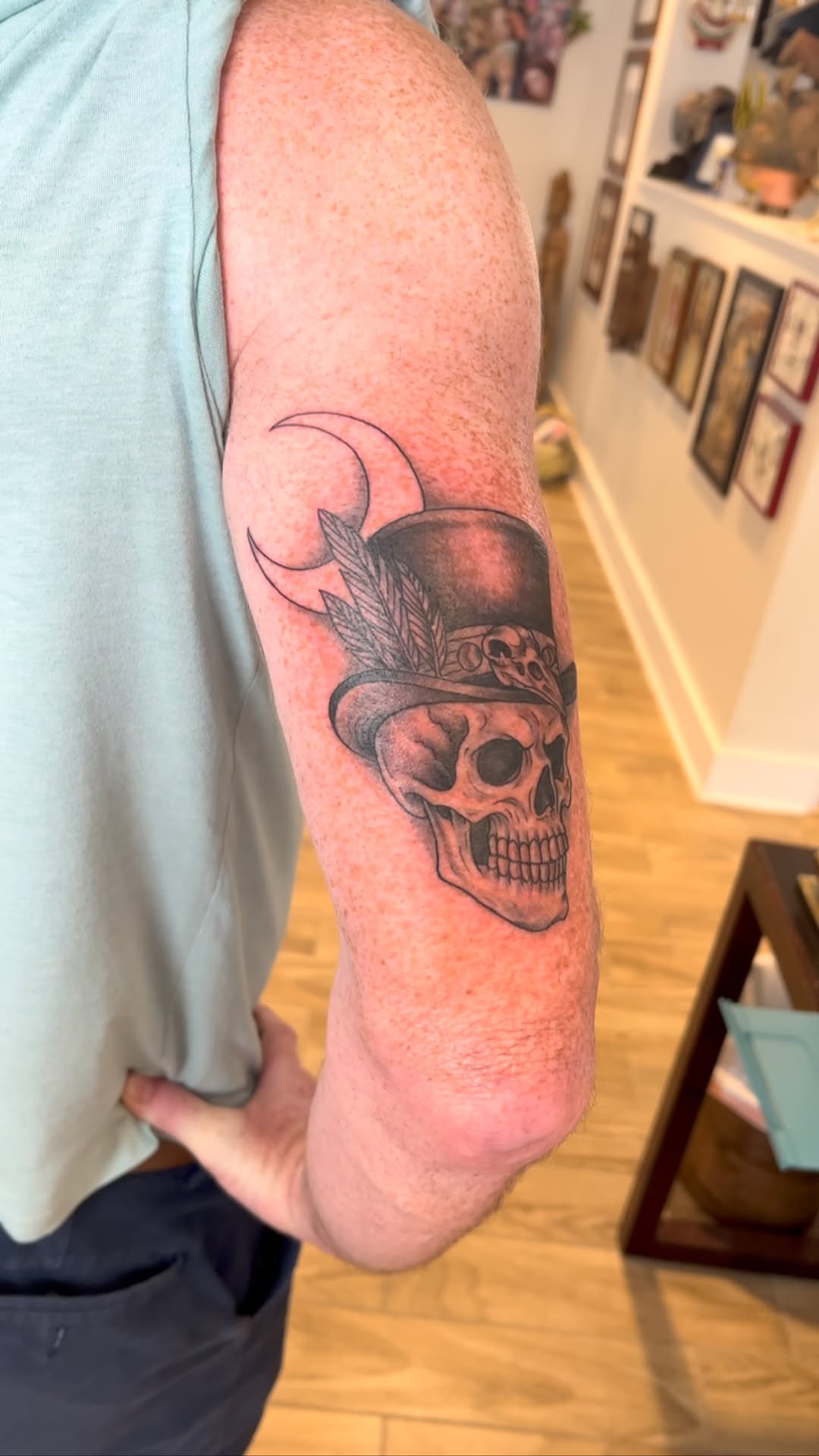 Bold skull with top hat, crescent moons, feathers