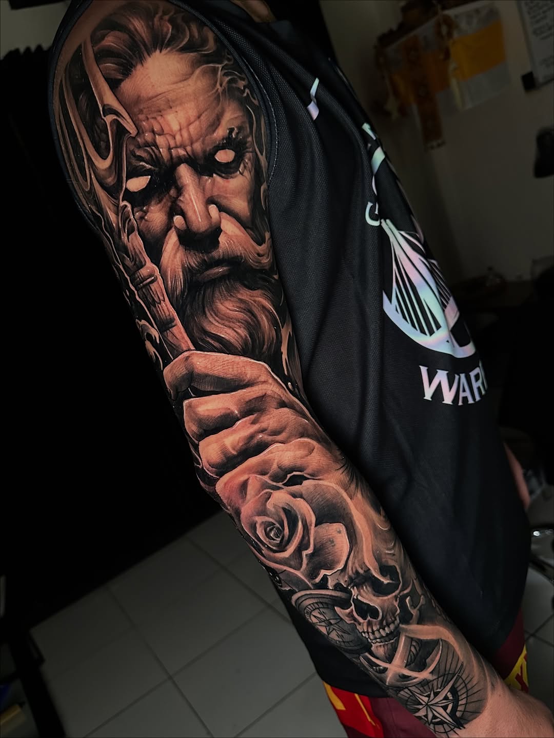 Dramatic black-and-gray realism sleeve featuring stern elder, rose, skull