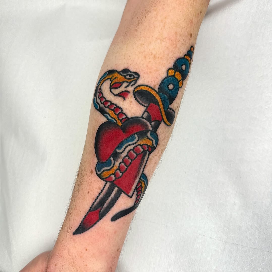 Bold traditional heart pierced by dagger with a snake