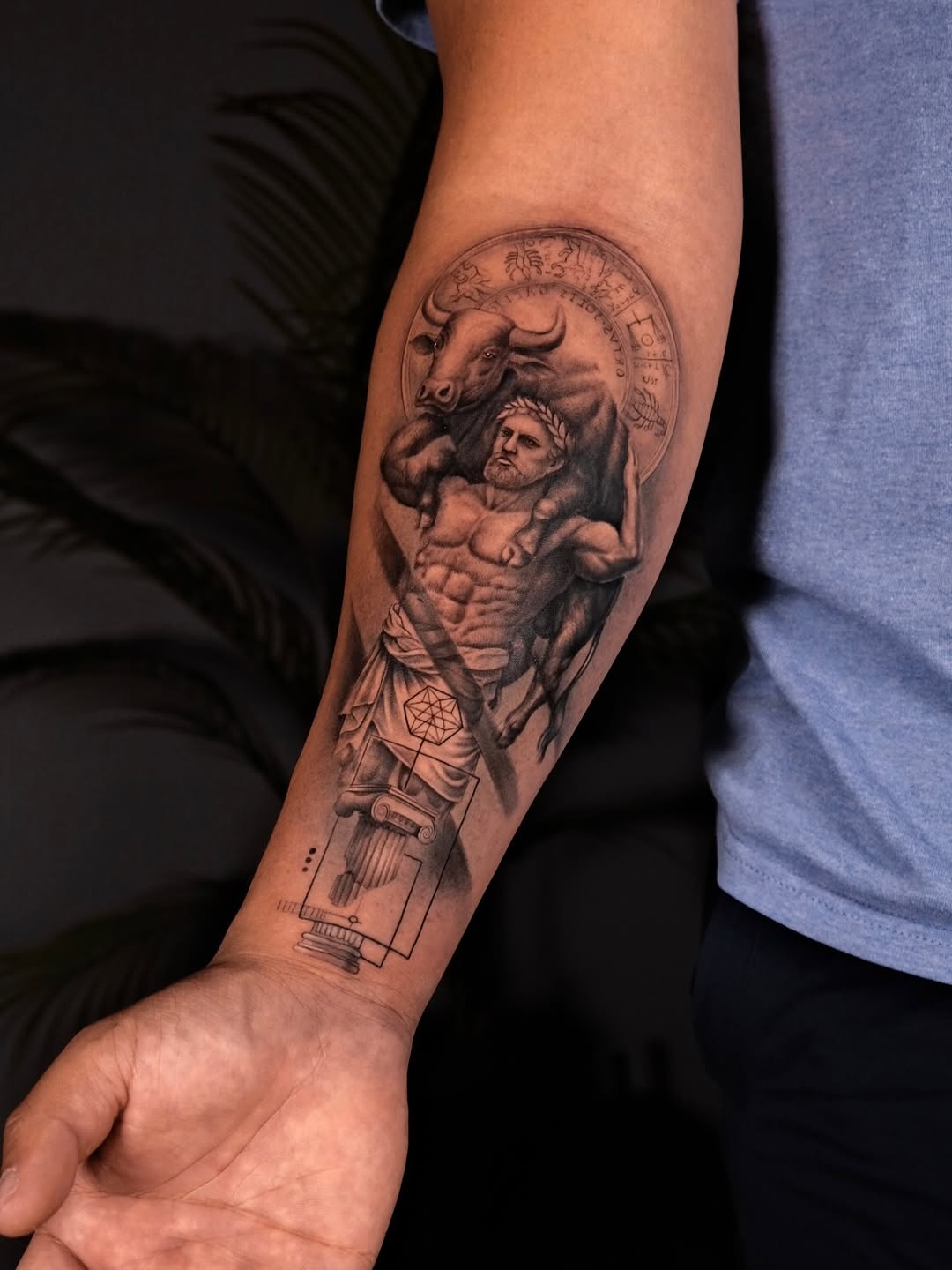 Bold black-and-gray realism of mythic hero with bull and geometry