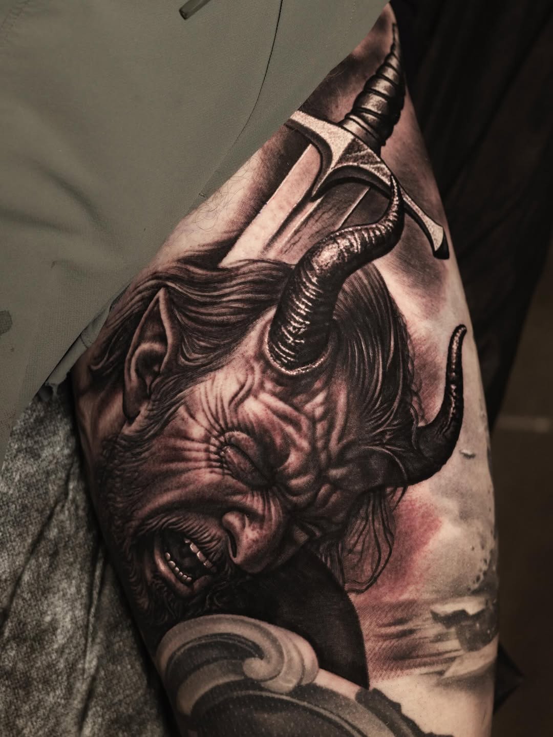 Hyper-detailed black-and-gray demon with curling horns and sword