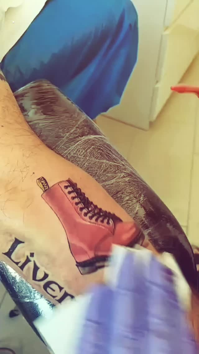 Playful pink boot tattoo with bold outline and shading