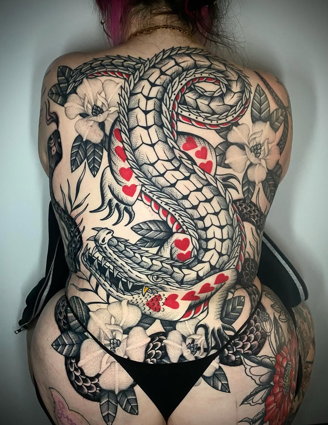 Bold black-and-gray serpent entwined with hearts and florals