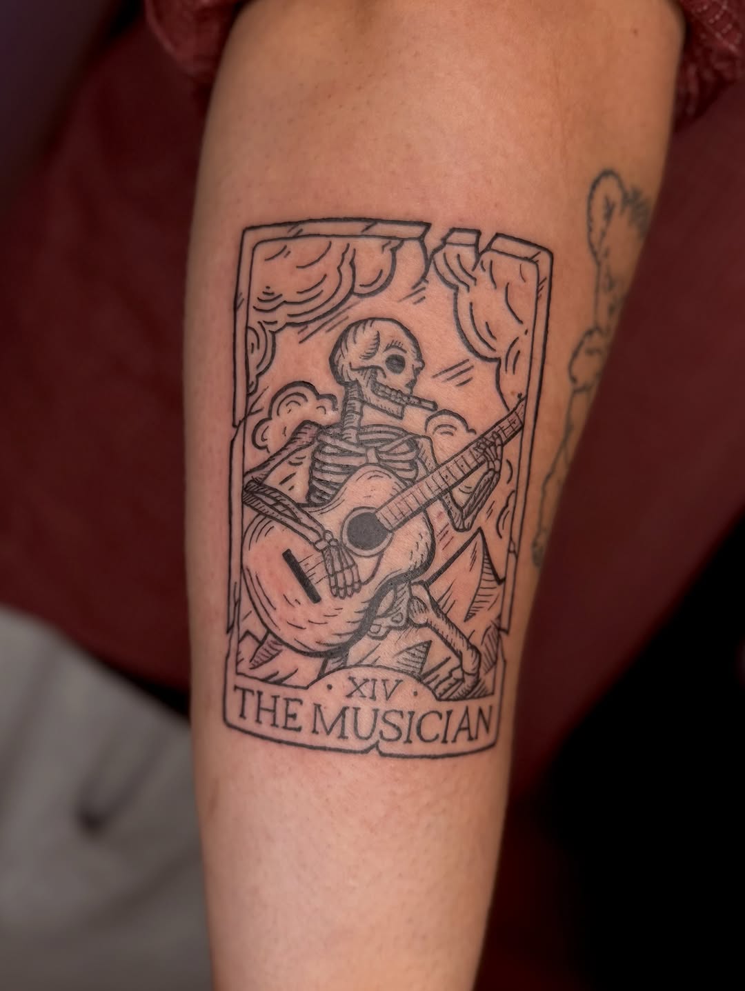 Tarot-card skeleton guitarist with clouds, bold linework.