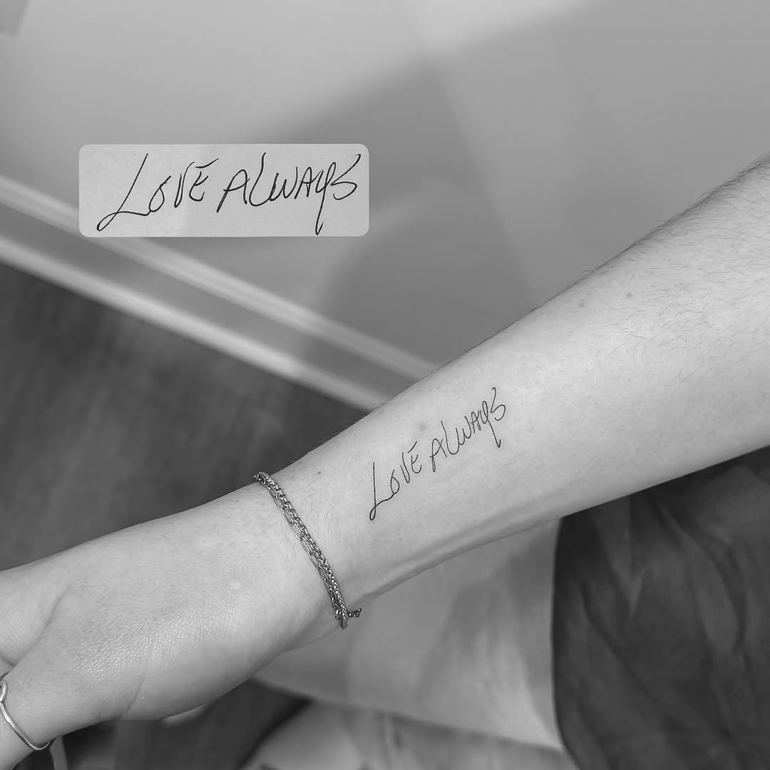Elegant handwritten script in fine-line lettering on forearm.