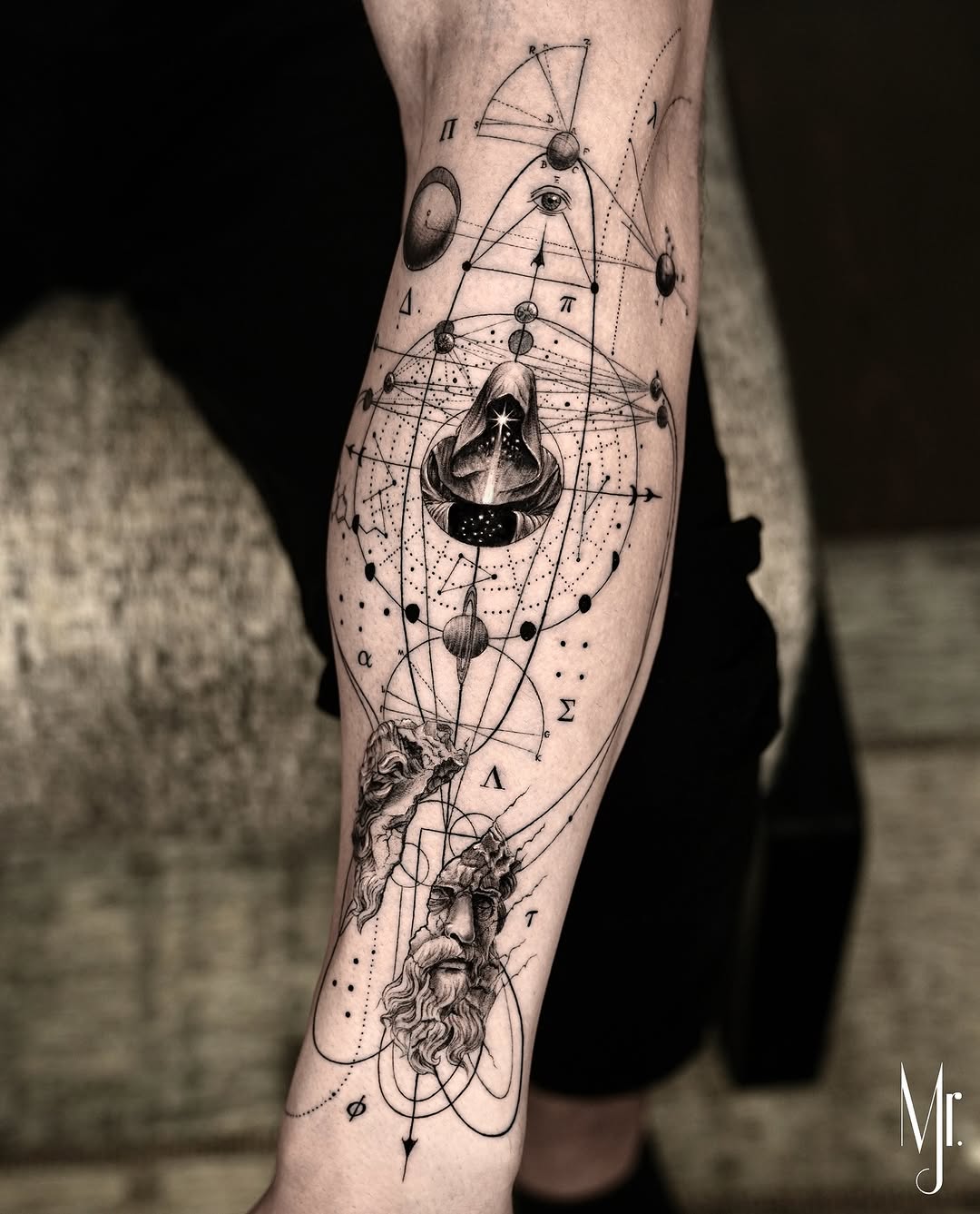 Intricate geometric celestial tattoo with orbiting spheres and bearded figure