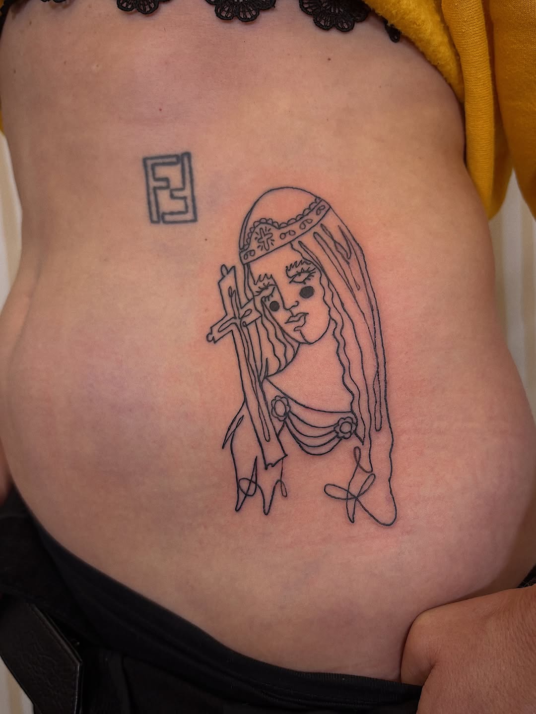 Tattoo of a woman with a cross