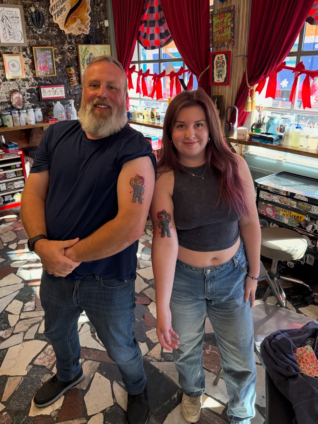 Vibrant cartoon duo tattoos on bold upper arms