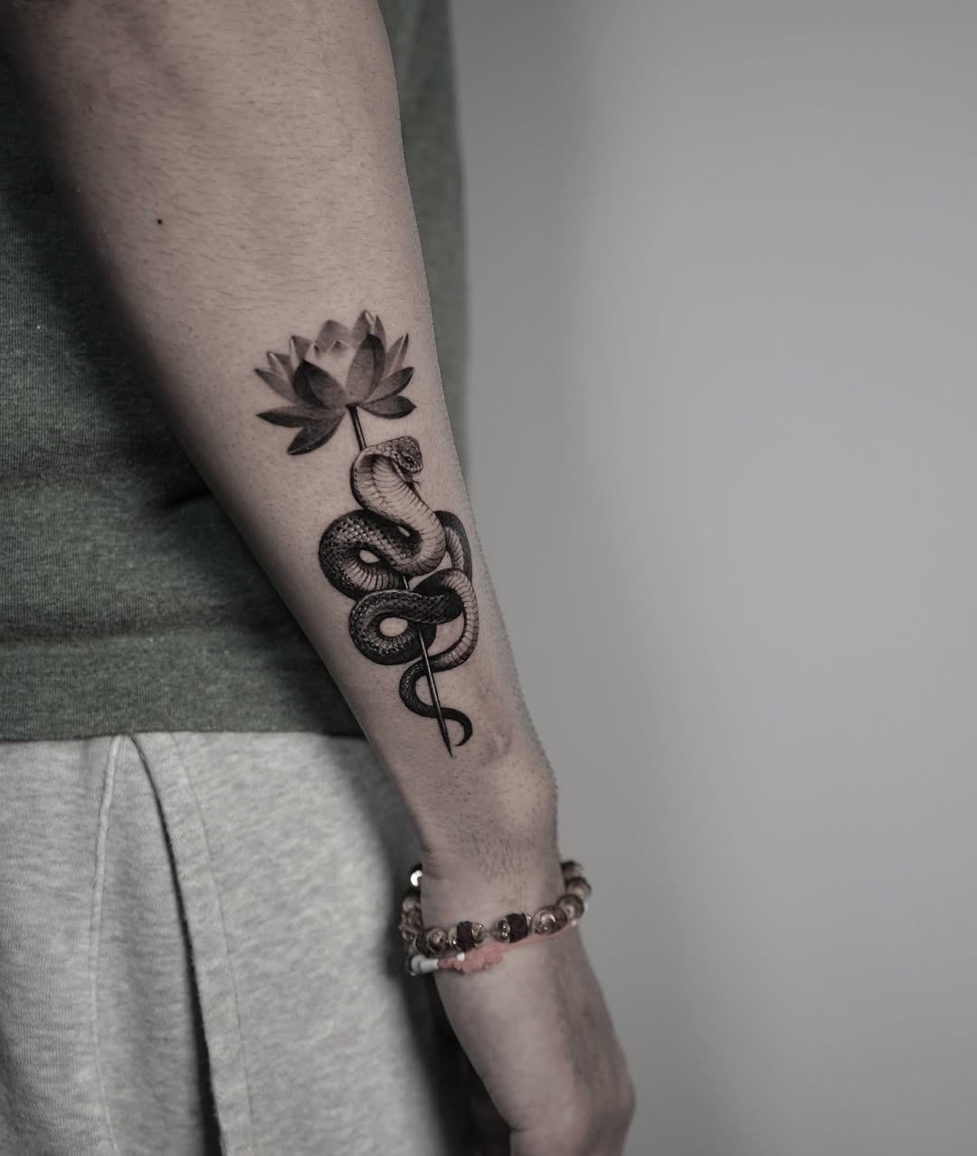 Coiled cobra wrapped around stem with lotus bloom