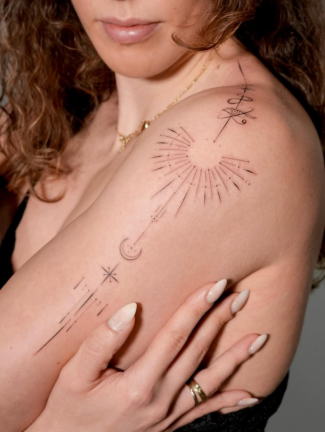 Delicate geometric sunburst with celestial linework along shoulder