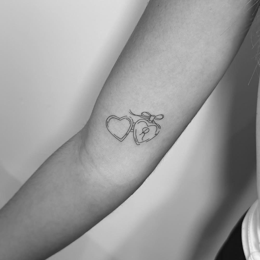 Delicate fine-line double-heart tattoo with ribbon charm