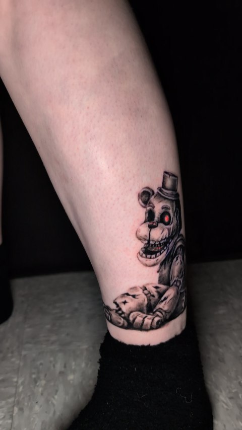 Dark realism Freddy Fazbear leg tattoo with crisp shading